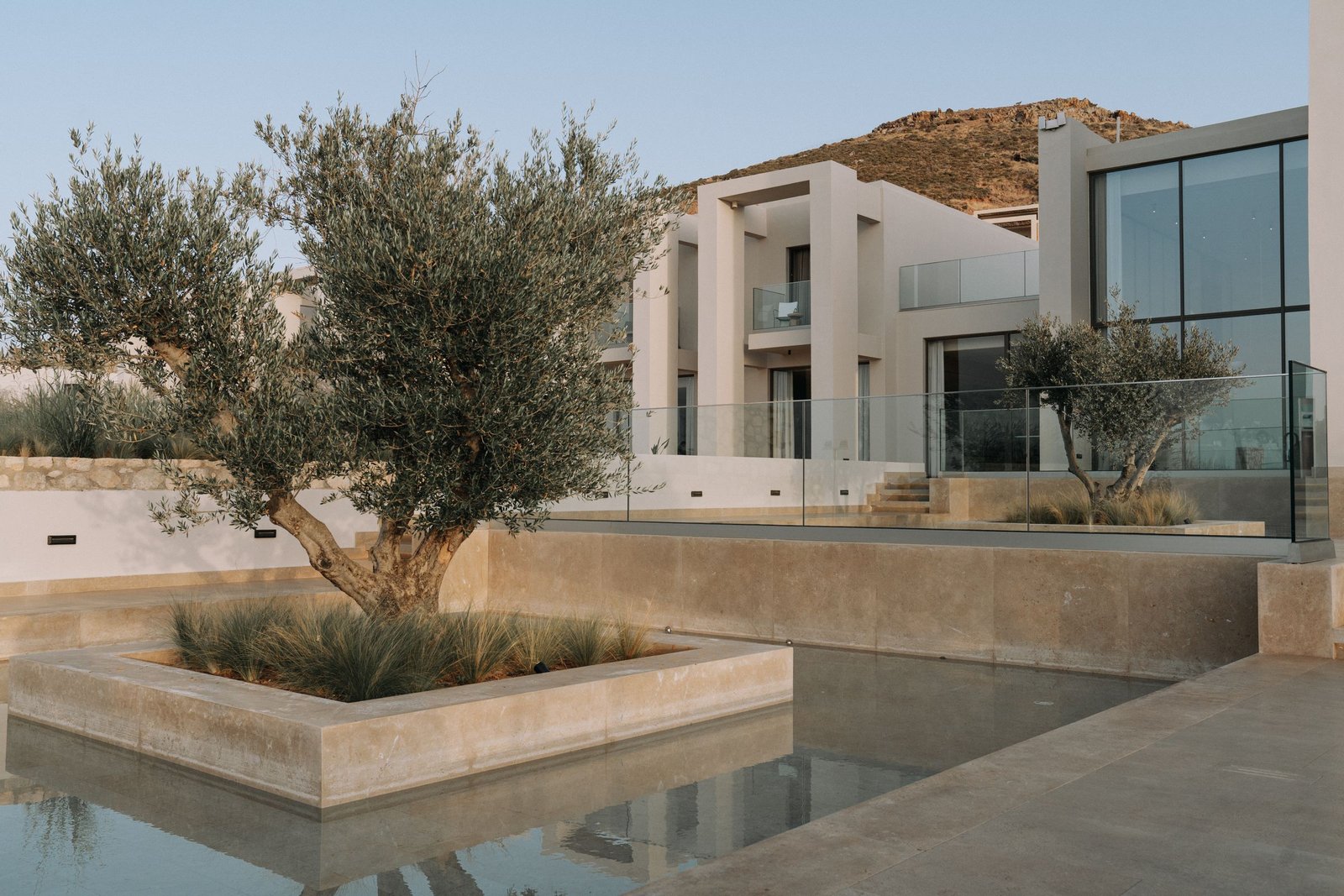 Modern residence with stone terraces, glass windows and landscaped gardens — illustrative property image